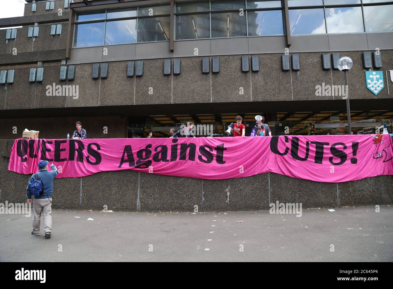 Queers protestano contro i tagli con un lungo banner rosa davanti all'Università della tecnologia, Sydney a Broadway. Foto Stock