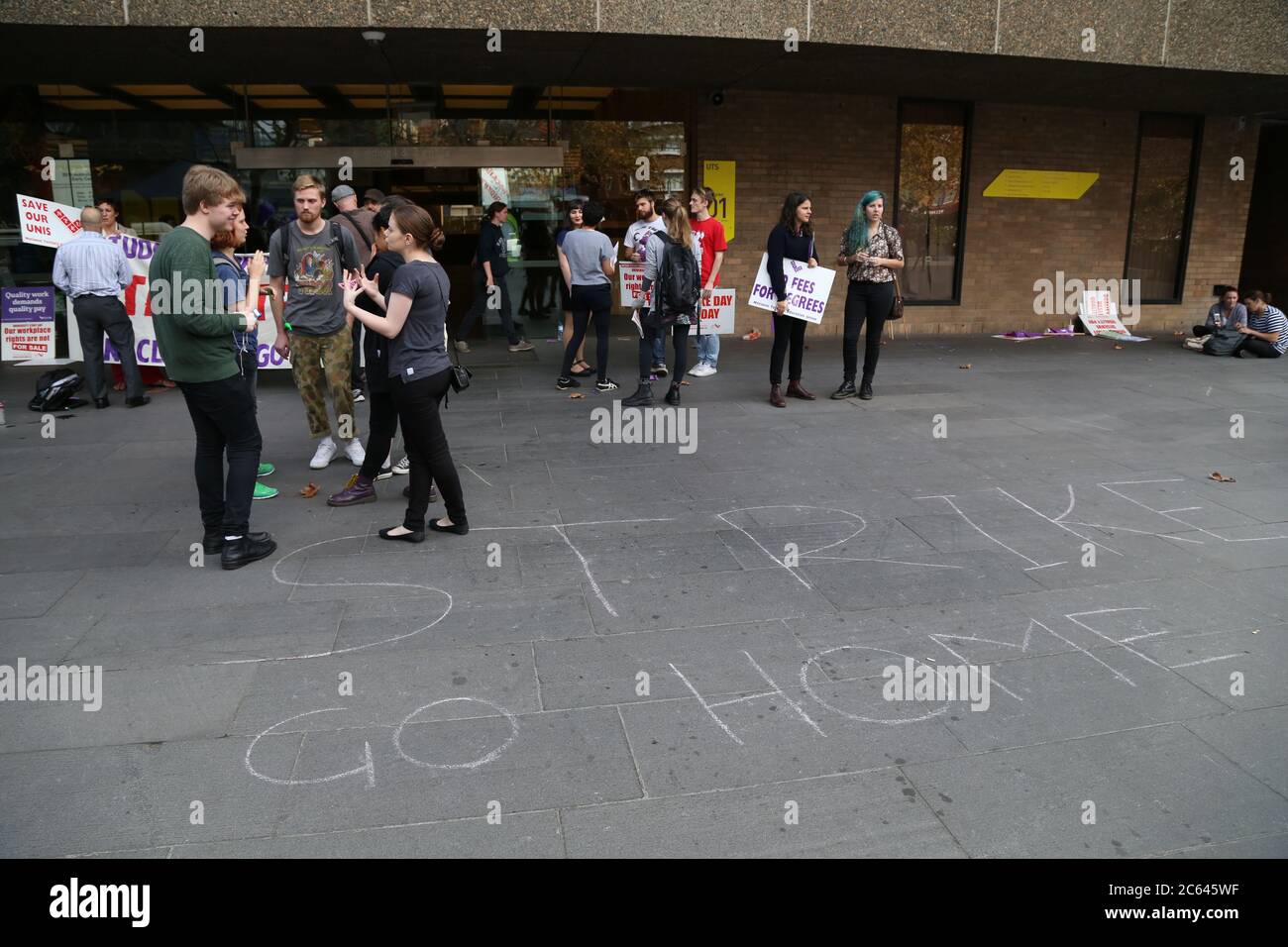 "Strike go home" è scritto in gesso sul terreno, fuori dall'ingresso principale dell'Università della tecnologia di Sydney. Foto Stock