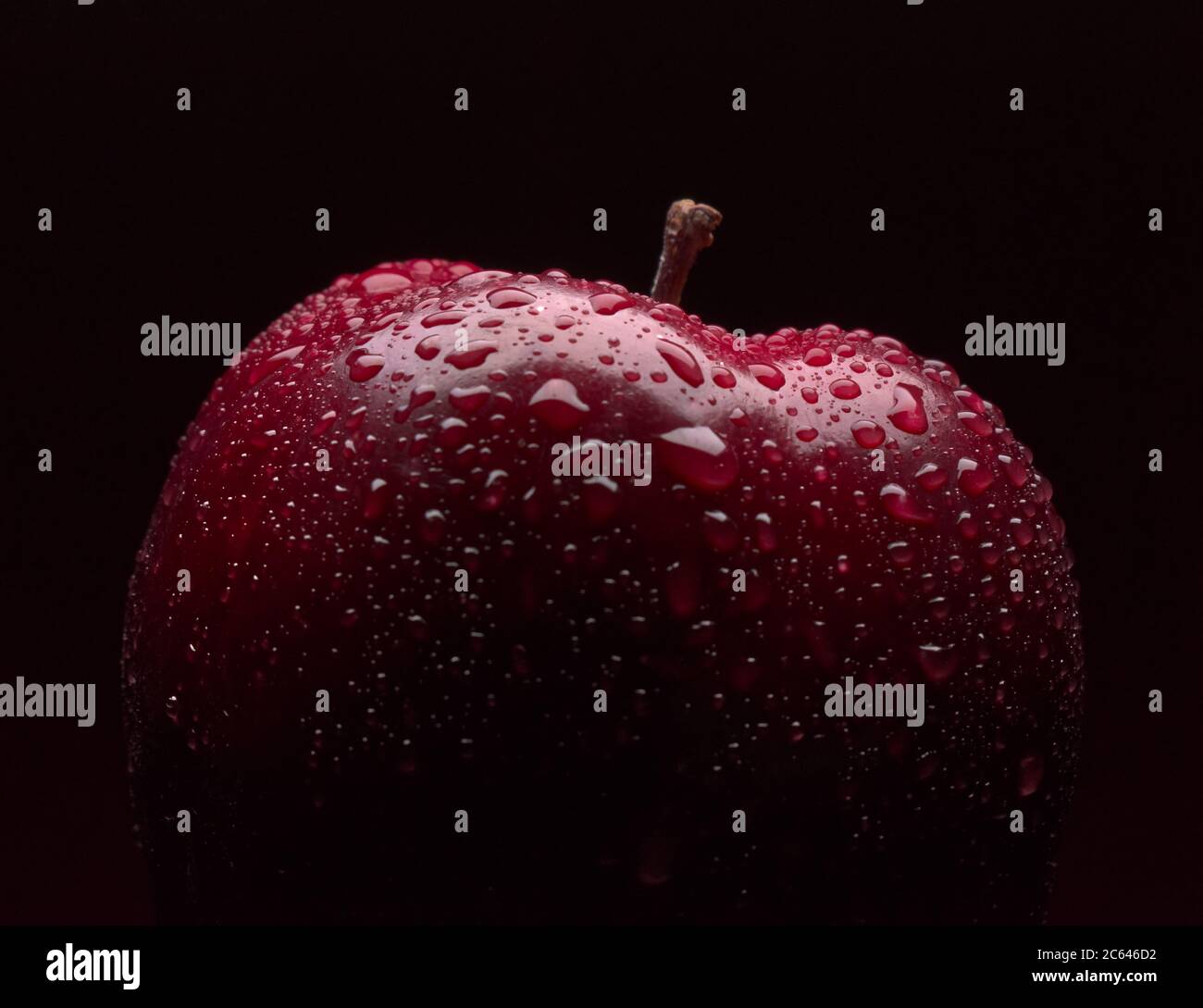 Pioggia su Red Apple con sfondo scuro Foto Stock