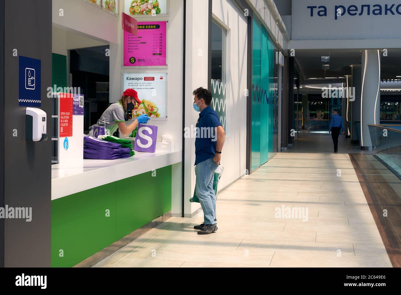 Ristorante di corte di cibo ai centri commerciali durante la quarantena Coronavirus COVID-19 . Consegna del cibo da portare via. Orientamento sociale che si allende persone che si tengono dentro Foto Stock