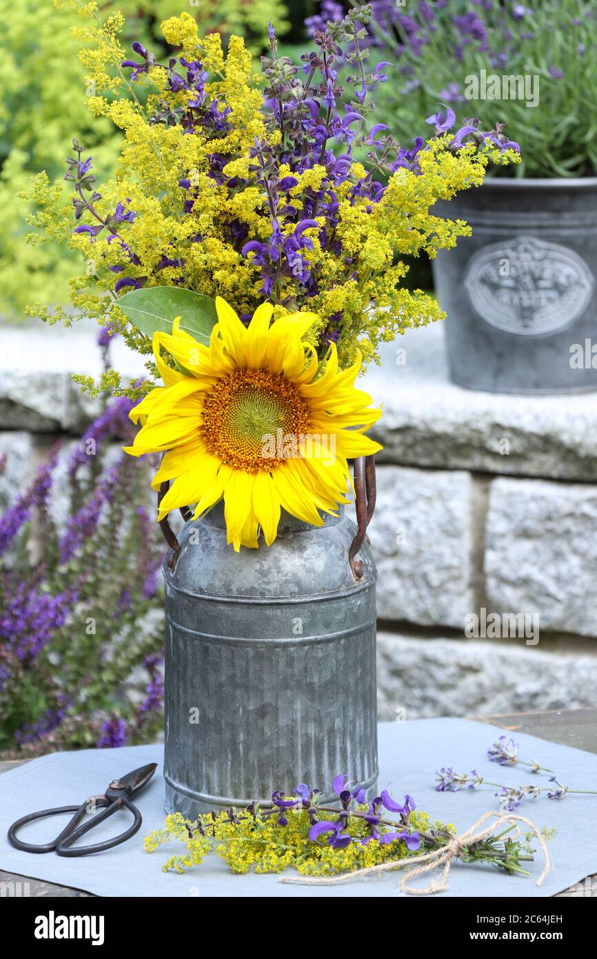 bouquet con fiore di sole e fiori di prato in giallo e viola in annata Foto Stock