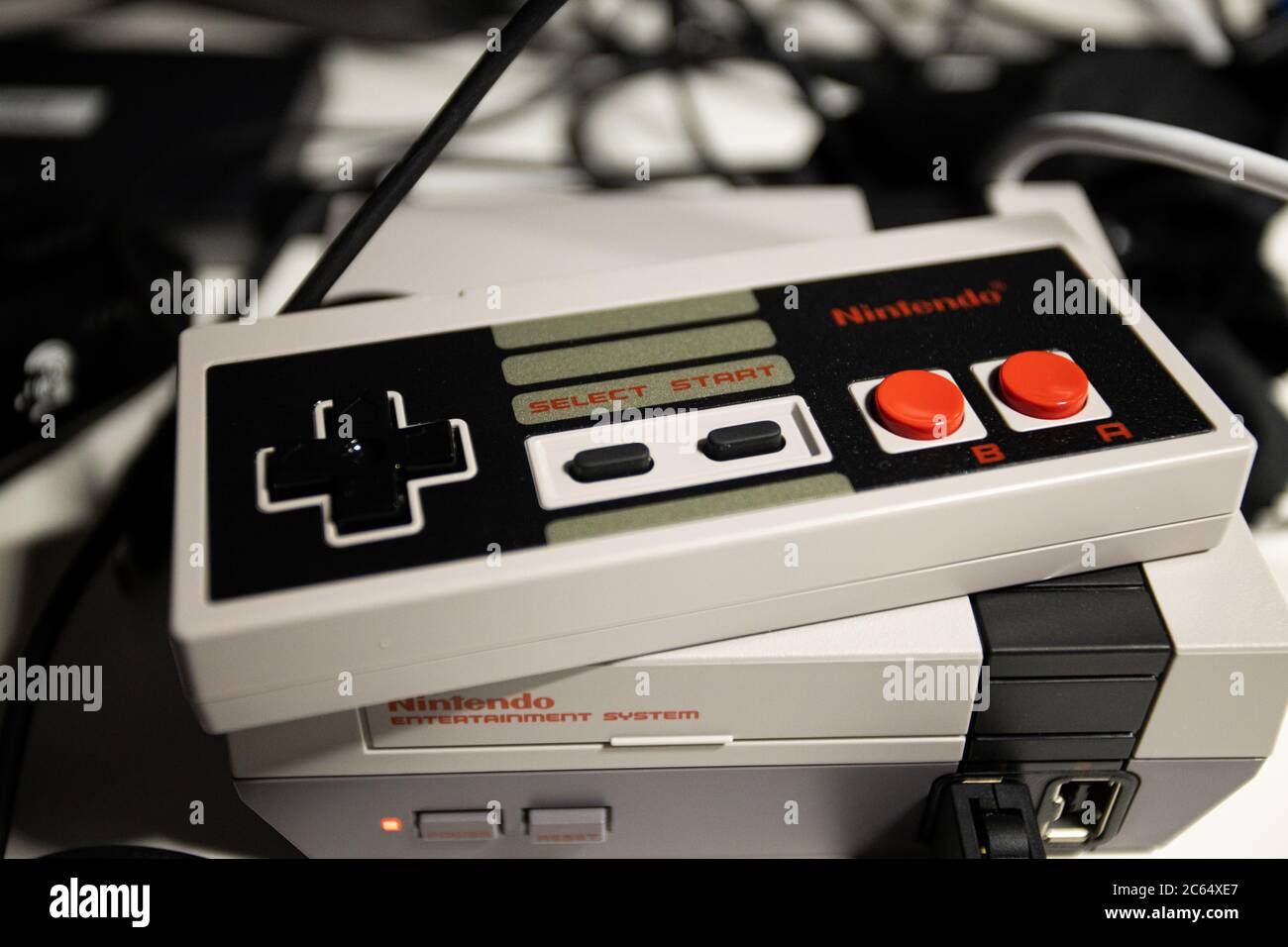 Giochi retrò. Nintendo Game Controller a 8 bit con pulsanti colorati e Mini NES (Nintendo Entertainment System) ripubblicato per il pubblico moderno Foto Stock