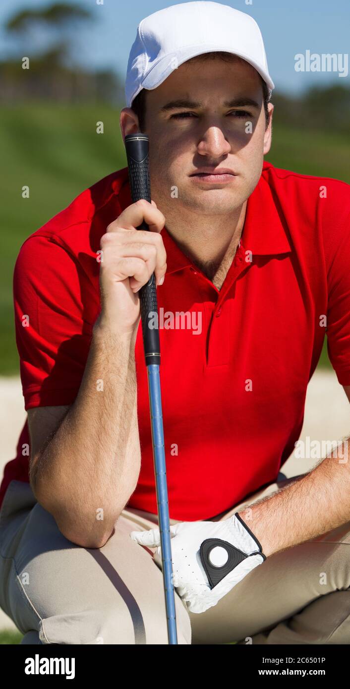 Ritratto di un golfista maschile con camicia rossa e cappellino da baseball bianco e guanto. Foto Stock