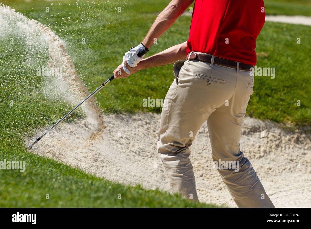 Il golfer maschio scheggiando fuori della trappola di sabbia. Foto Stock