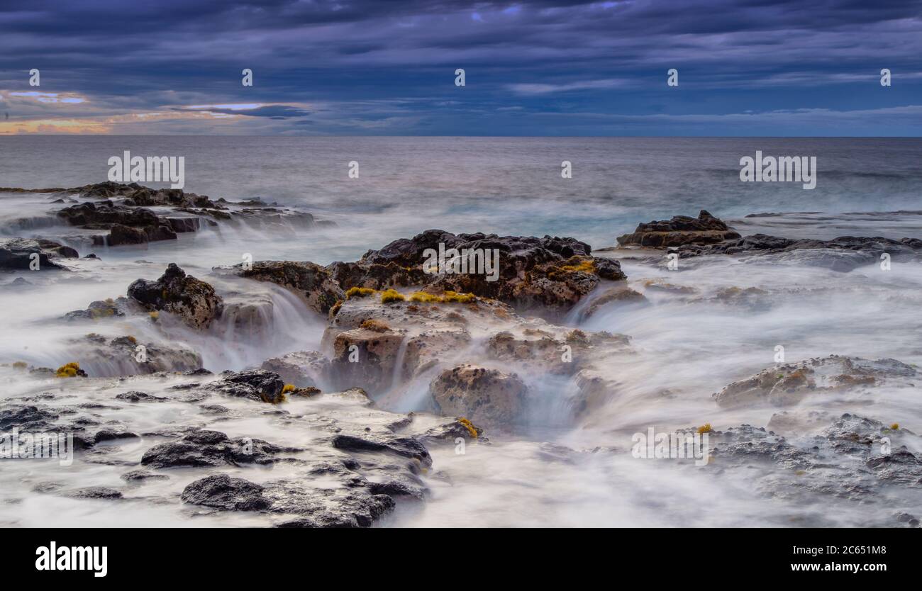 Onde oceaniche che riempia il pozzo di lava di Pele vicino a Wawaloli Beach sulla Big Island delle Hawaii, Stati Uniti. Foto Stock