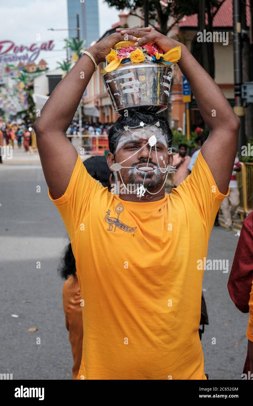 Uomo con lingua trafitto e punte nella sua pelle durante la processione del festival di Thaipusam, Little India, Singapore, febbraio 2020 Foto Stock