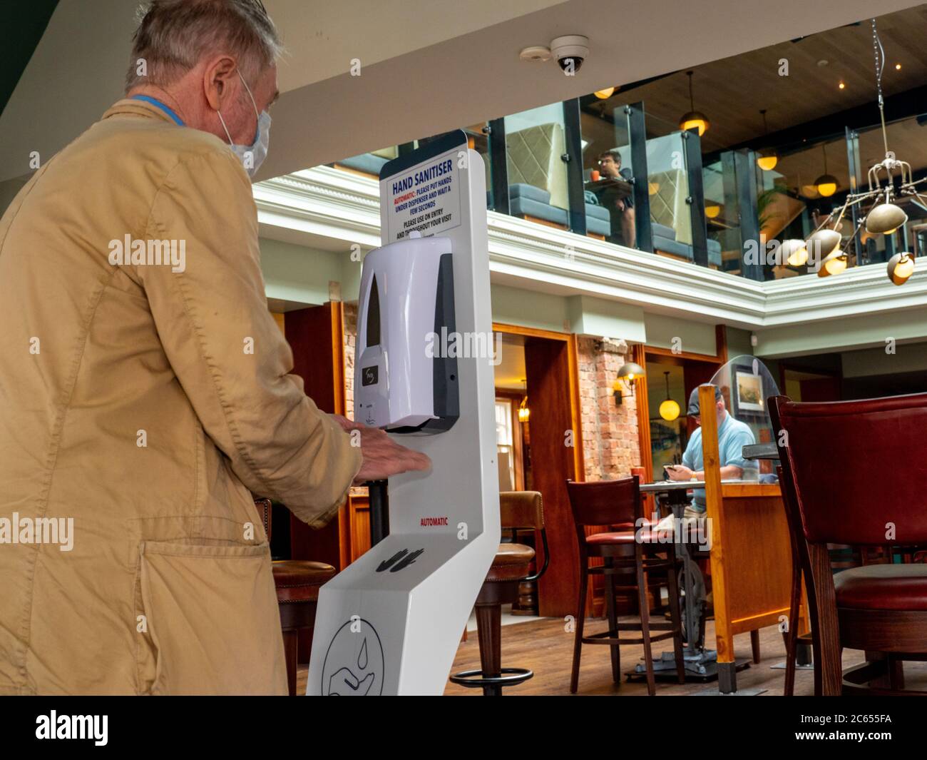 Un cliente si sanitizza le mani al Mossy Well, un pub J D Wetherspoon riapre per affari dopo Coronavirus Lockdown a Muswell Hill, Londra. Foto Stock