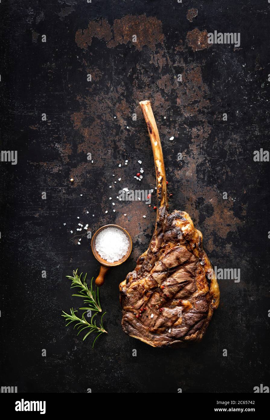 Bistecca di manzo tomahawk alla griglia con spezie su sfondo rustico scuro Foto Stock