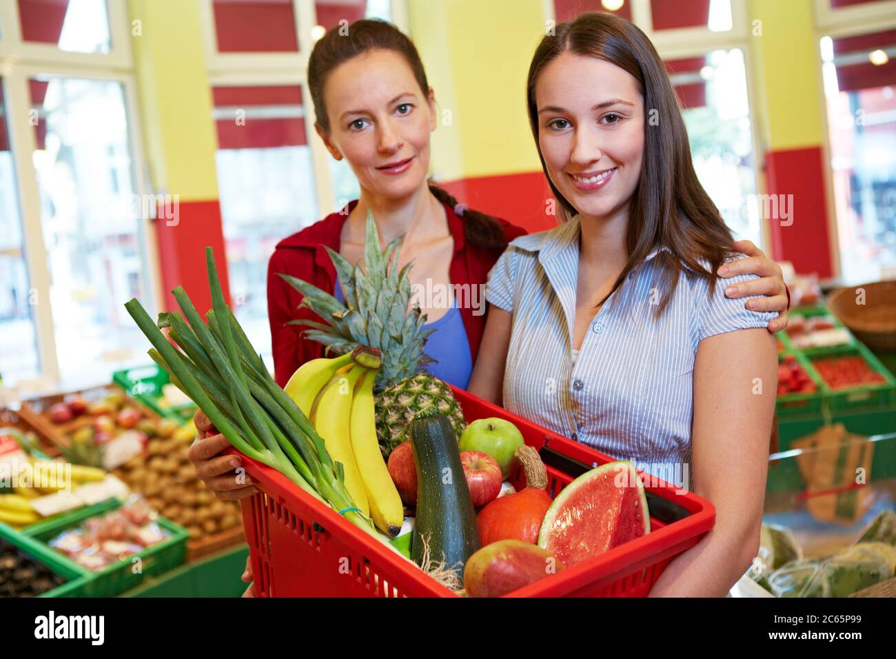 Madre e figlia con il cestino pieno di shopping nel supermercato Foto Stock