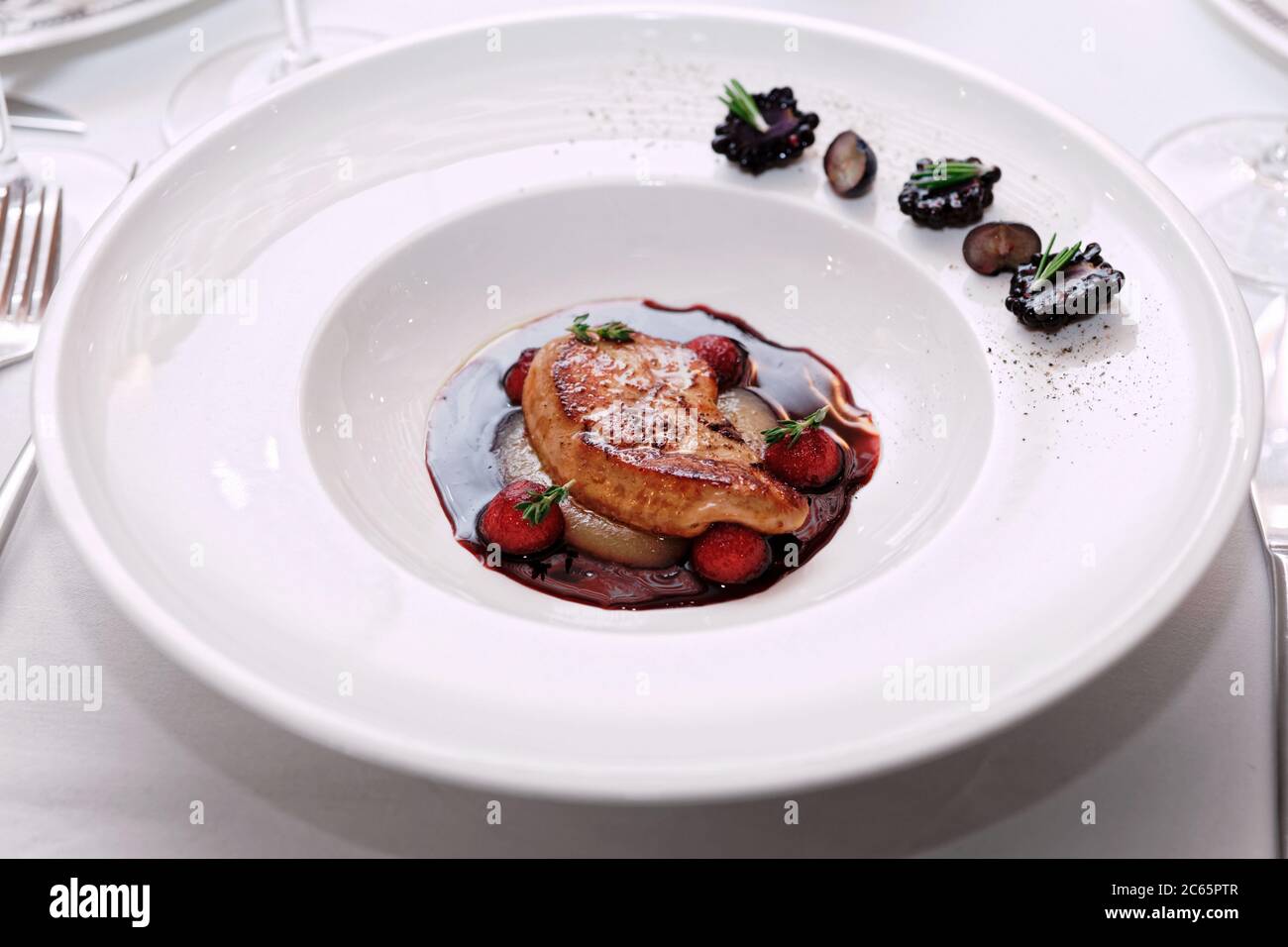 Foie gras fritto con salsa al porto sul tavolo da ristorante, tonato Foto Stock