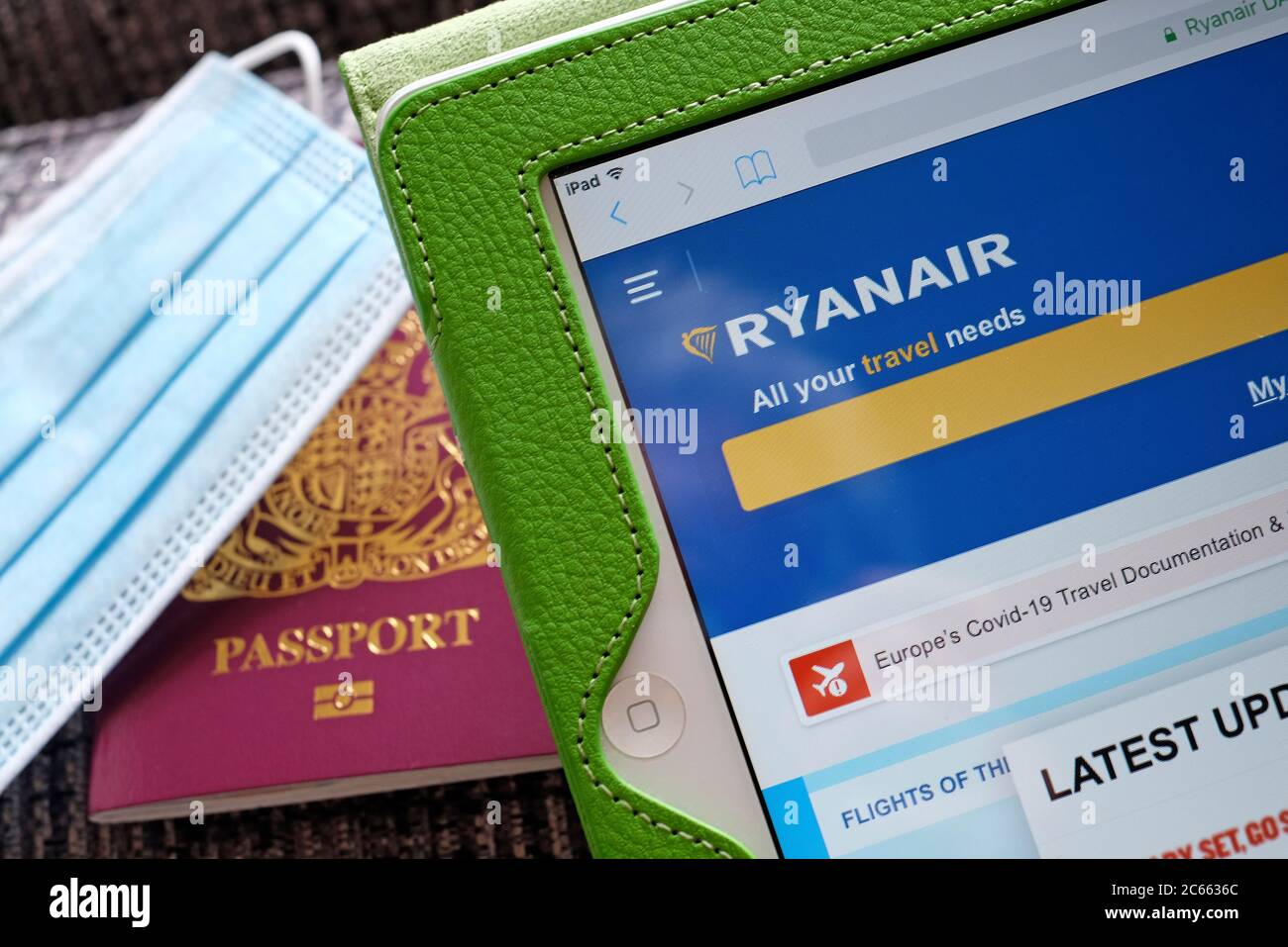 sito web di ryanair su ipad tablet computer con passaporto britannico e maschera facciale Foto Stock