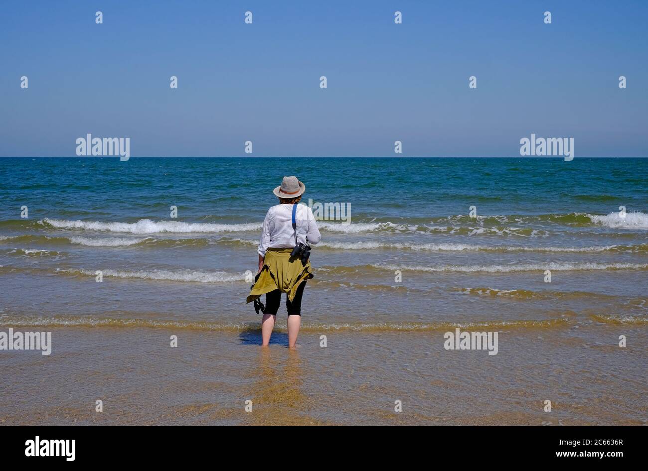 senior femmina che guarda verso il mare, holkham beach, norfolk settentrionale, inghilterra Foto Stock