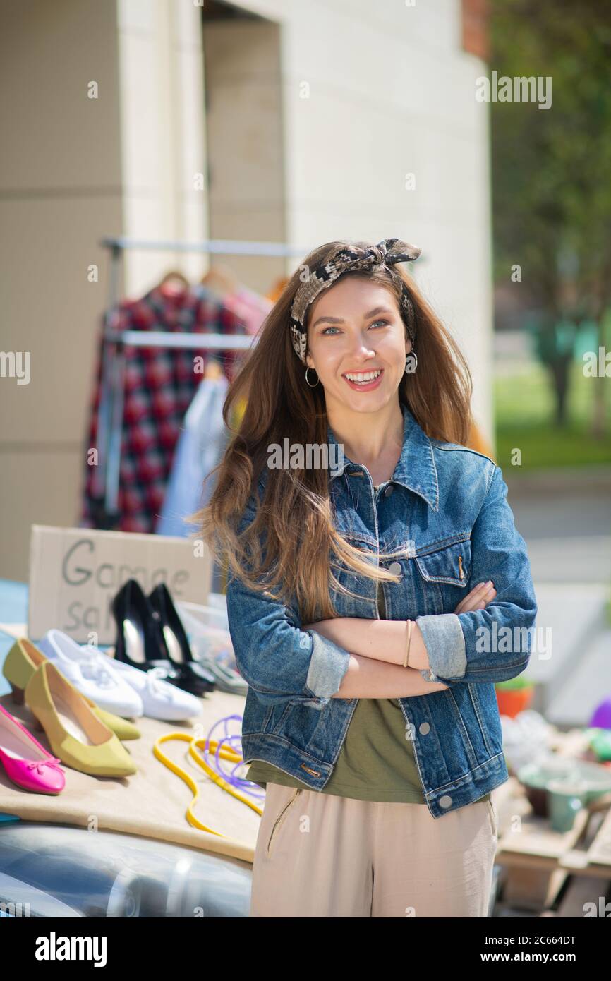 Felice donna con capelli lunghi in piedi con mano a croce Foto Stock