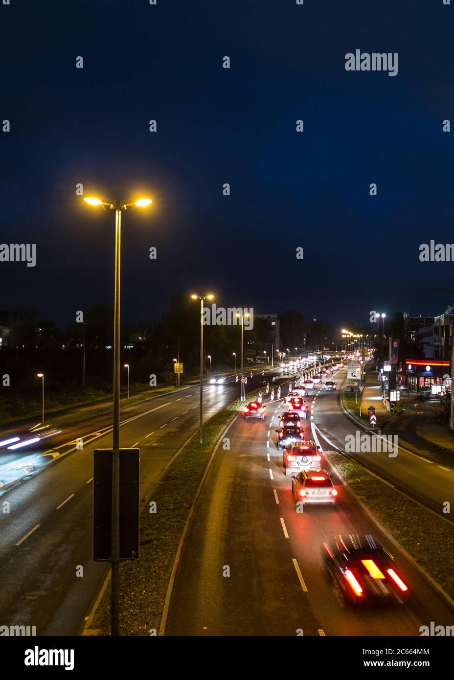 Traffico notturno su una strada illuminata Foto Stock