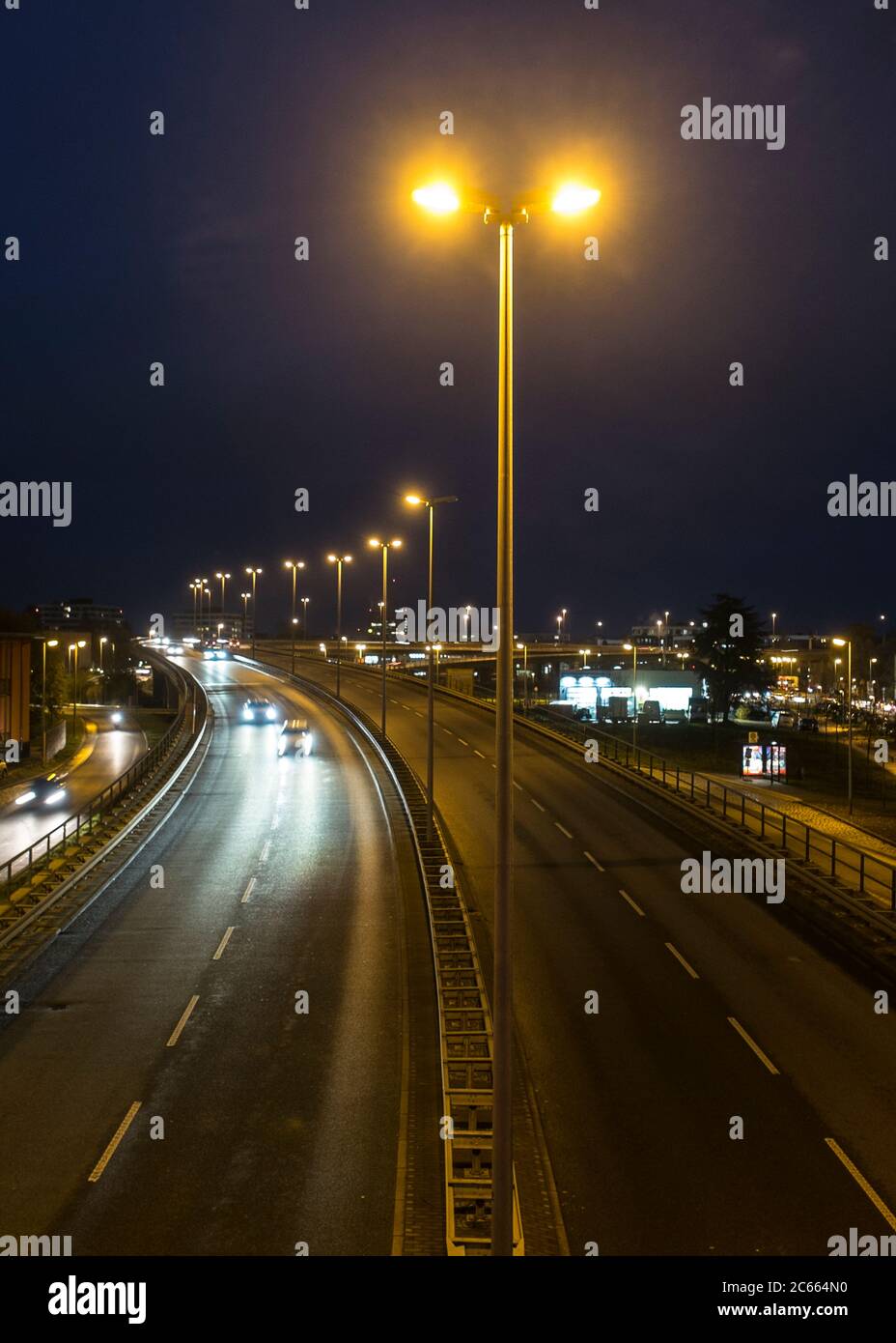 Traffico notturno su una strada illuminata Foto Stock