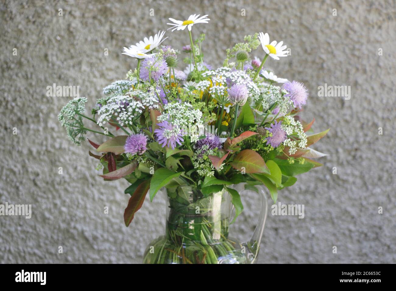 Bouquet di fiori di prato 'impressionistica' di fronte ad una parete approssimativamente strutturata Foto Stock