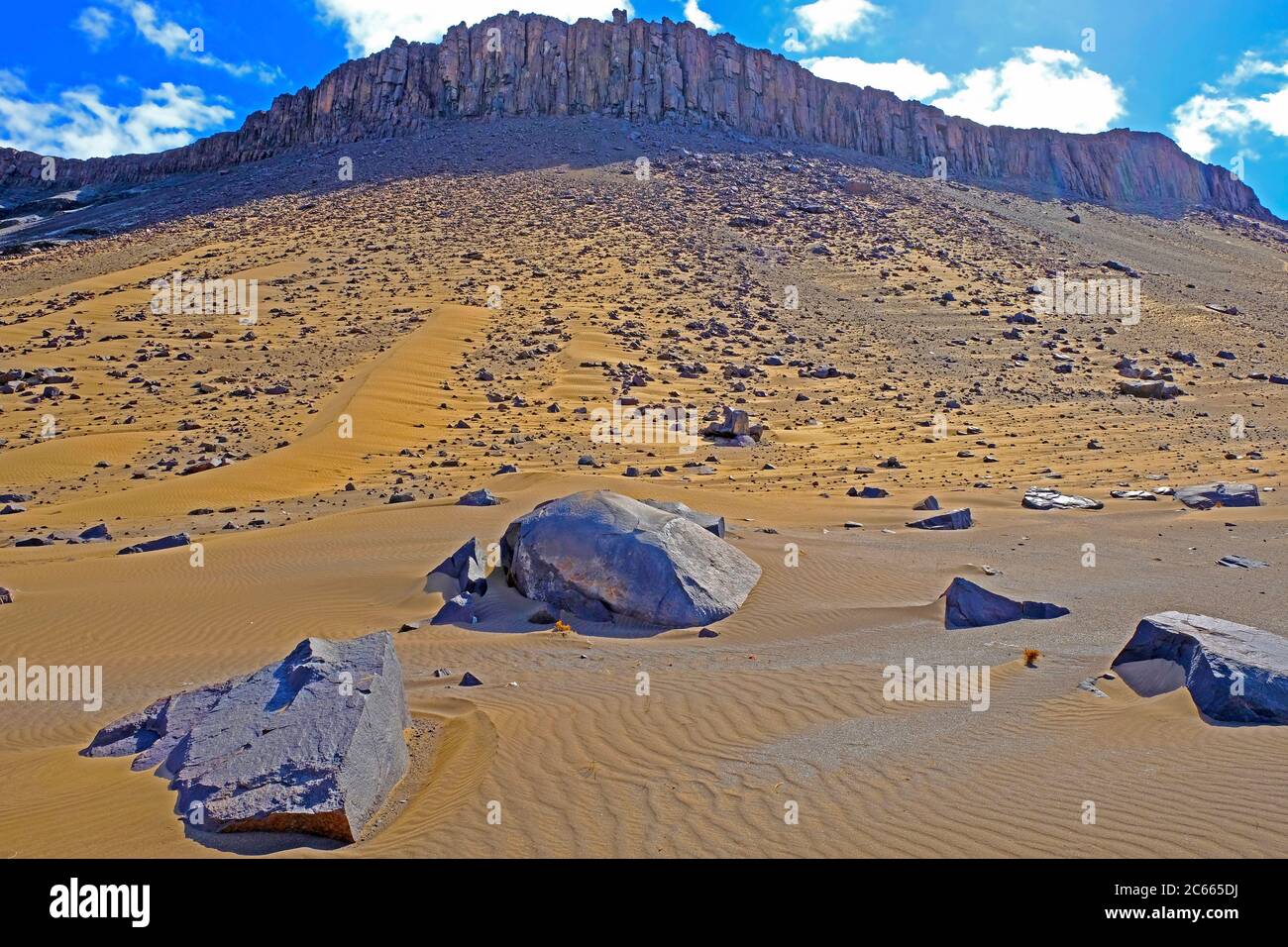 Dune intervallate da massi su un pendio roccioso sul fiume di confine Oranje tra Namibia e Sud Africa Foto Stock