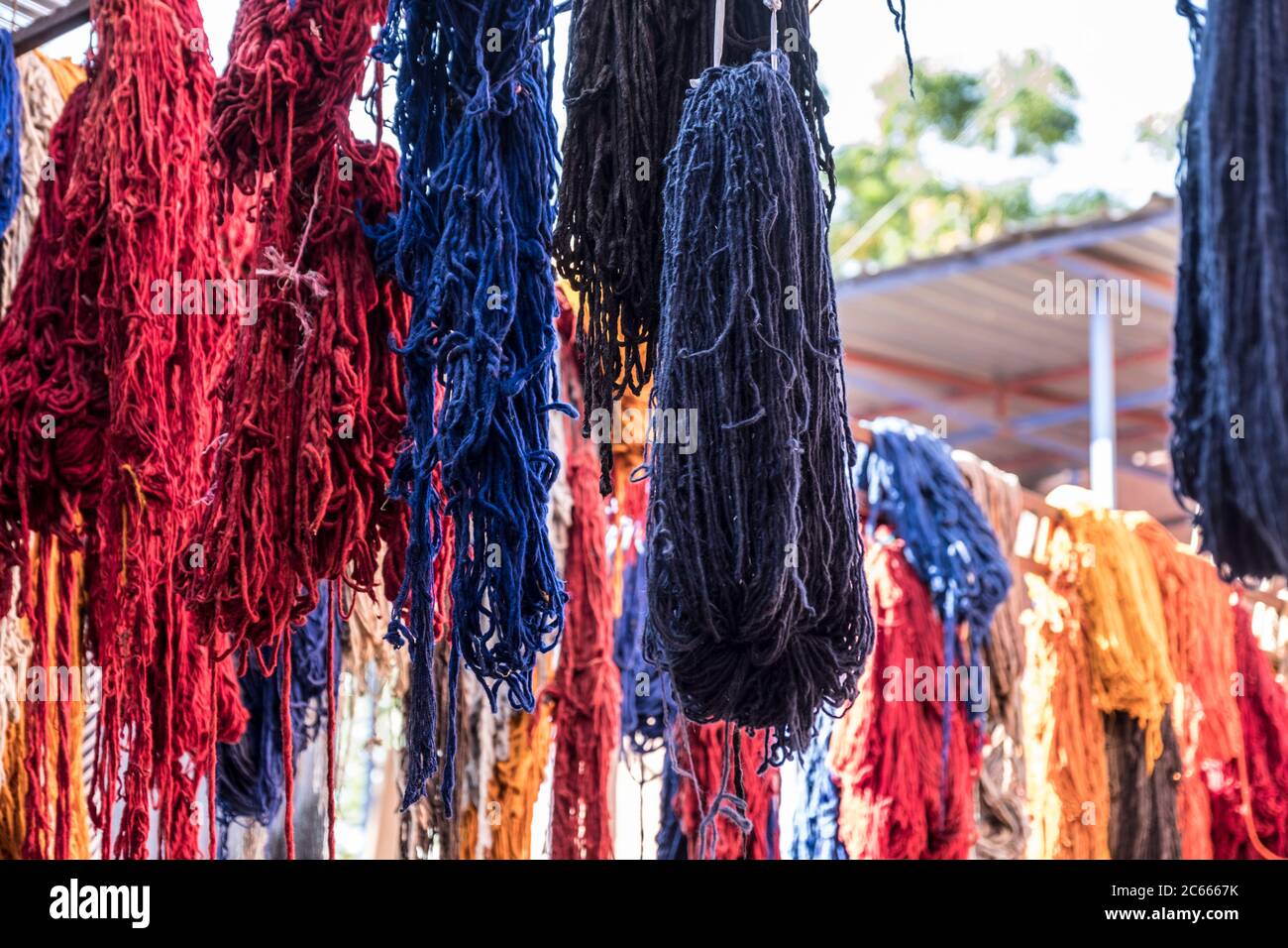 Lana colorata a secco appesa nel distretto di tintura di Marrakech, Marocco Foto Stock
