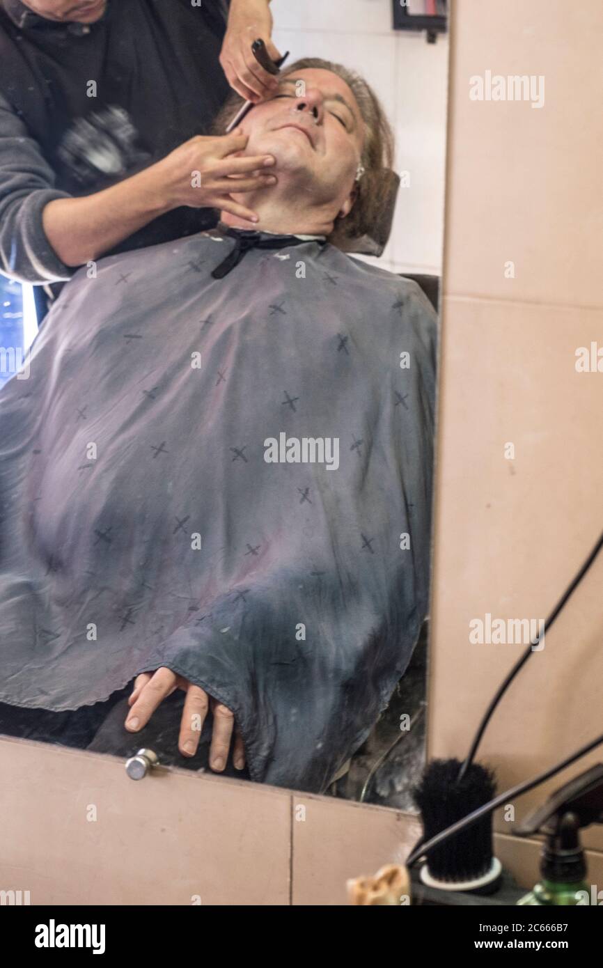 L'uomo ha una rasatura da un barbiere a Marrakech, Marocco. Foto Stock