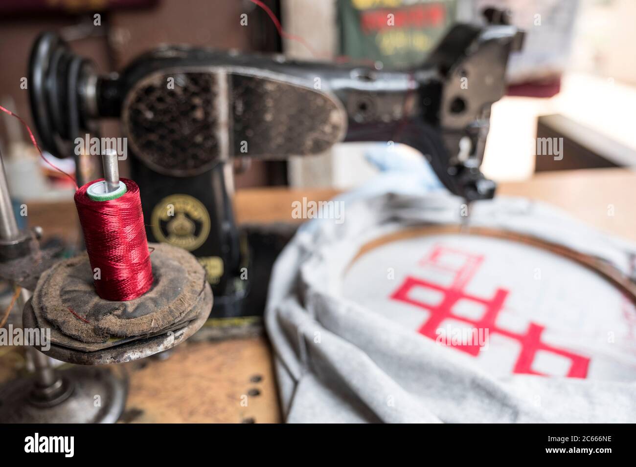 Bobina per filo con macchina da cucire in un negozio di t-shirt a  Kathmandu, Nepal Foto stock - Alamy
