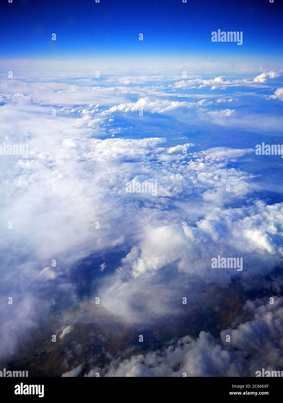 Campi nuvolati e terraferma visti dall'aereo Foto Stock