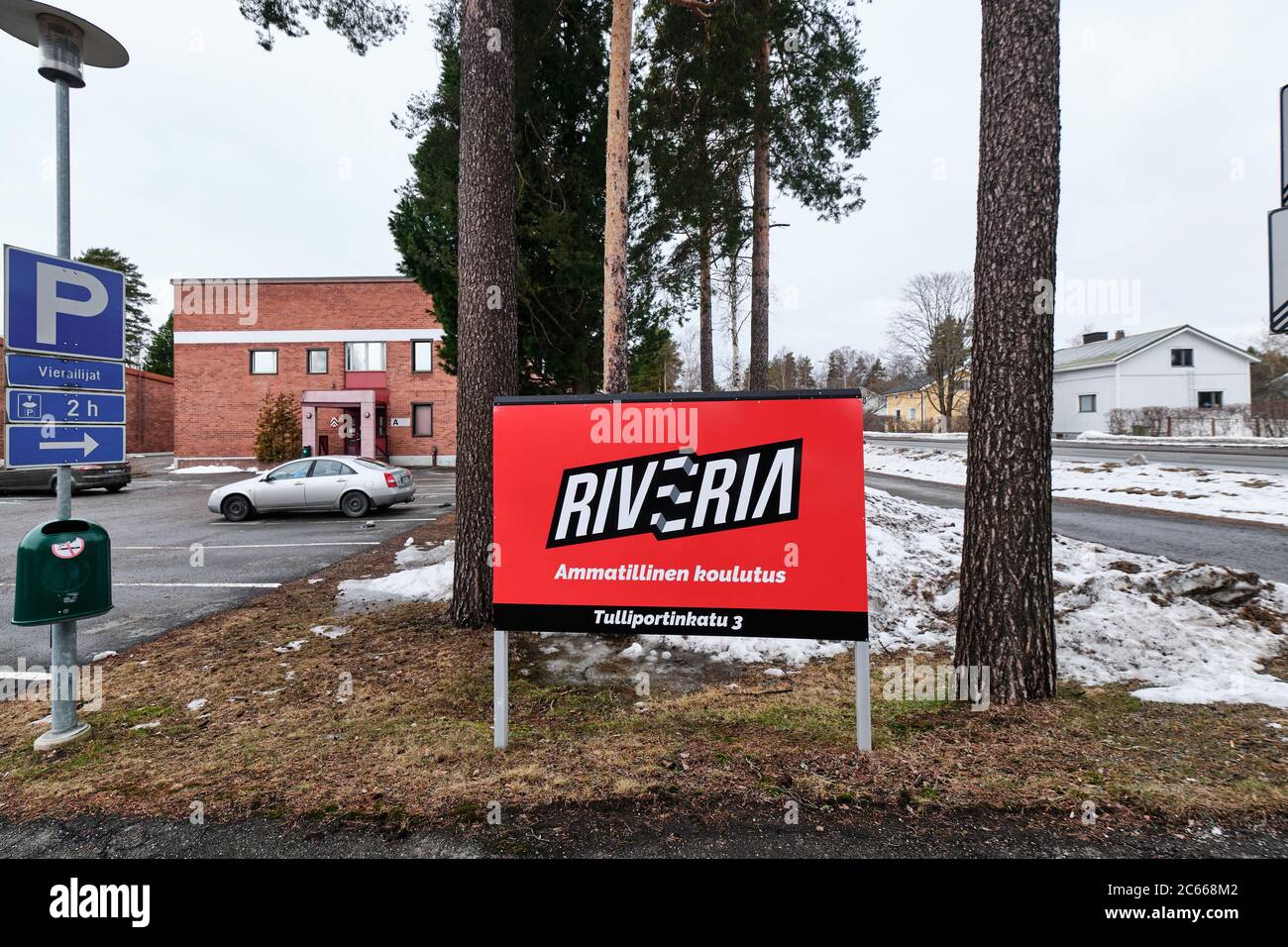 Joensuu, Finlandia - 13 marzo 2020: Cartello stradale Riveria - scuola professionale sullo sfondo edificio di Riveria. Foto Stock