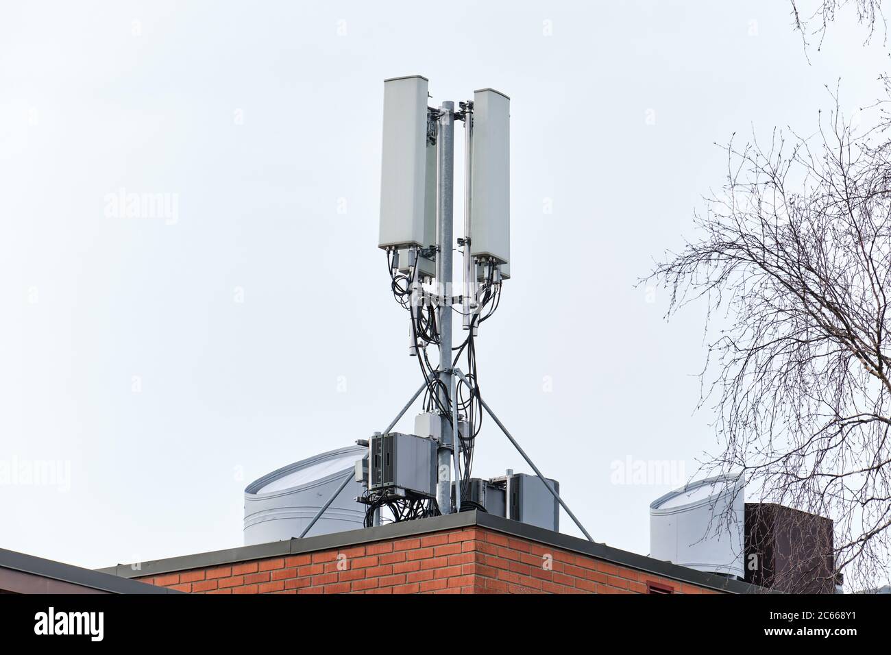 Torre di telecomunicazione della rete telefonica cellulare sul tetto dell'edificio. Foto Stock