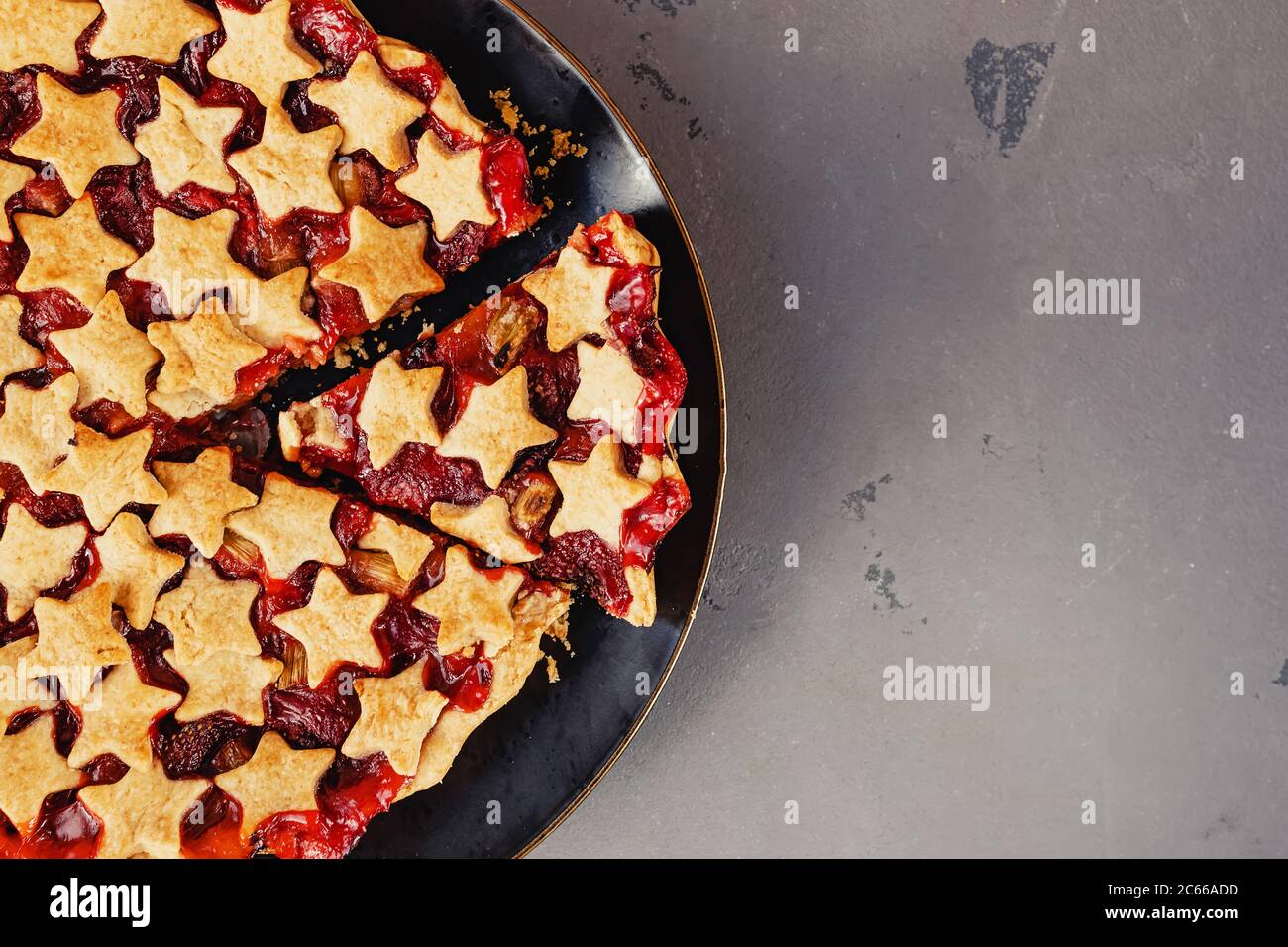 Torta di fragole e rabarbaro decorata con stelle su tavola bianca, vista dall'alto Foto Stock