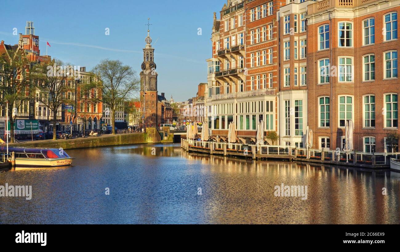 Amstel River presso l'Hotel de l'Europe e la Torre Munttoren, Amsterdam, Olanda del Nord, Paesi Bassi Foto Stock