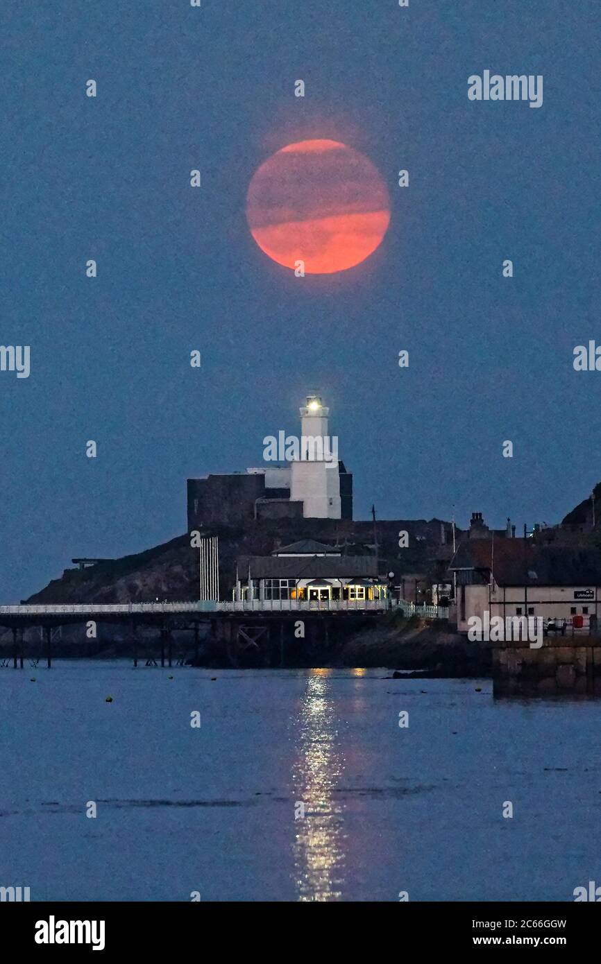 Una luna piena, conosciuta come Flower Moon, sorge sul faro di Mumbles vicino a Swansea, Galles, Regno Unito. Giovedì 07 maggio 2020 Foto Stock