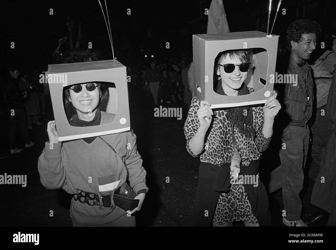 La TV si dirige alla Greenwich Village Halloween Parade, New York City, USA negli anni '80 fotografata con film in bianco e nero di notte. Foto Stock