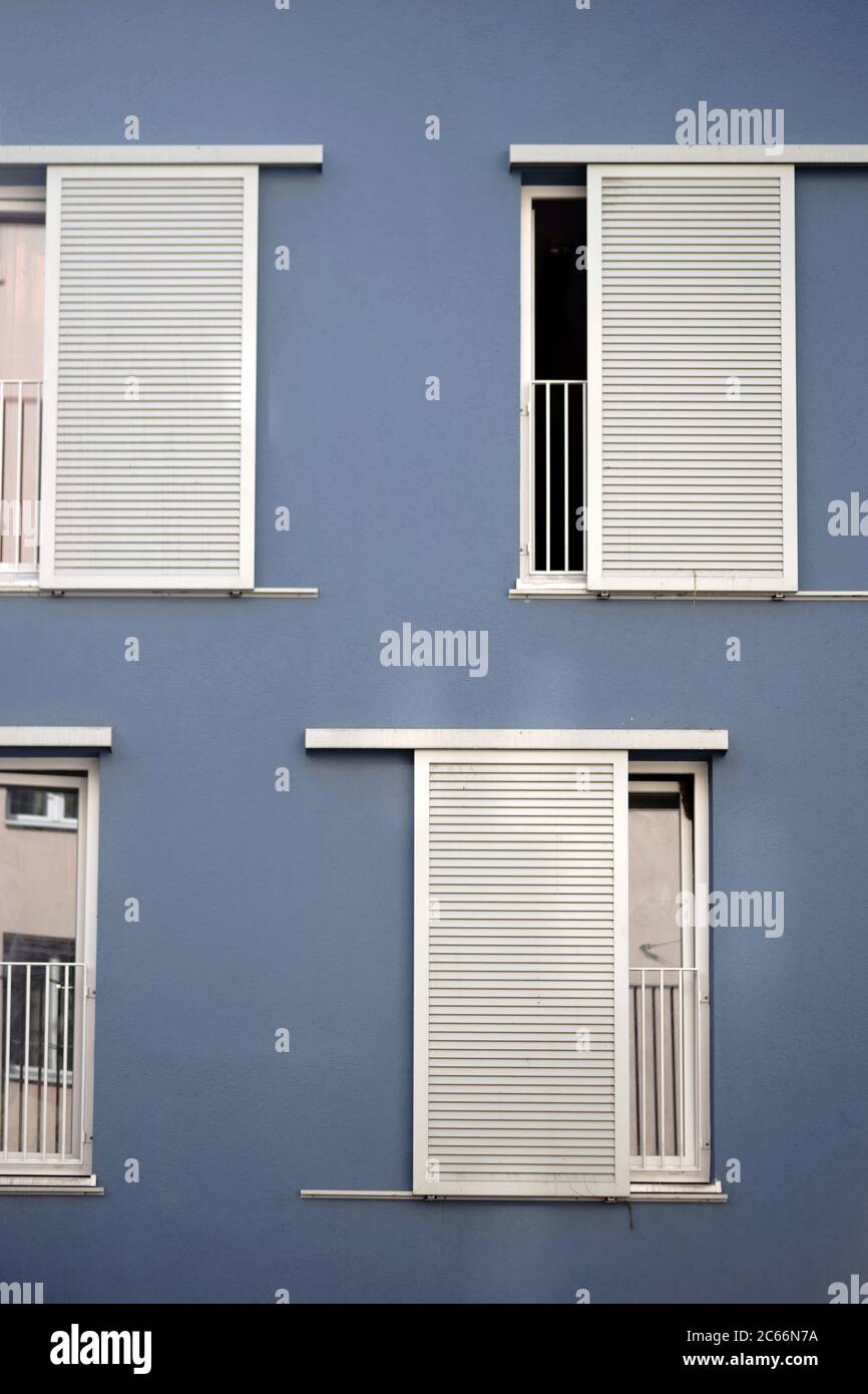 La facciata moderna di un edificio residenziale con file di finestre e persiane scorrevoli, Foto Stock