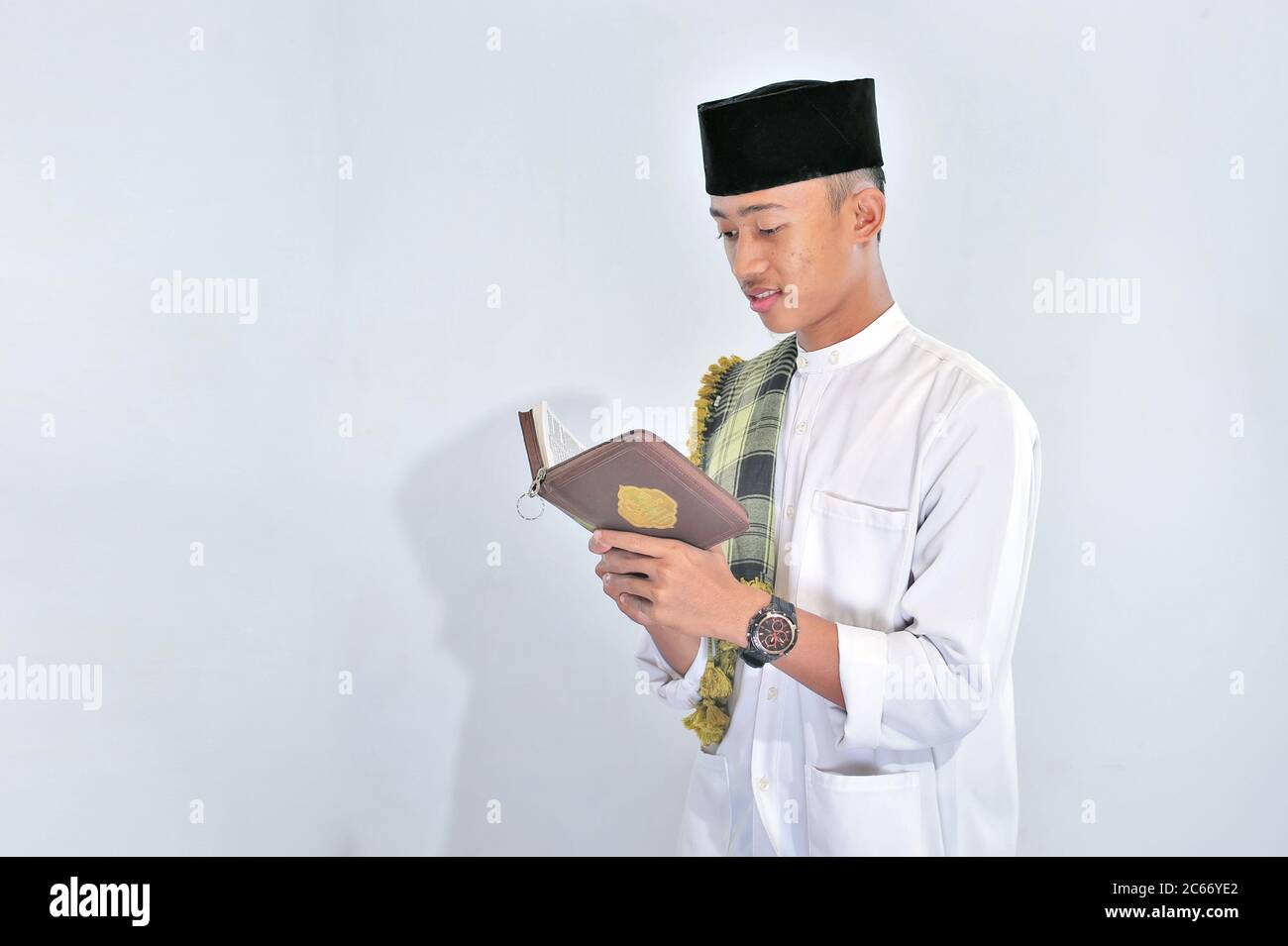 Ritratto di bel giovane musulmano piace leggere (tilawat ul quran) un santo Corano in Ramadan su sfondo bianco Foto Stock