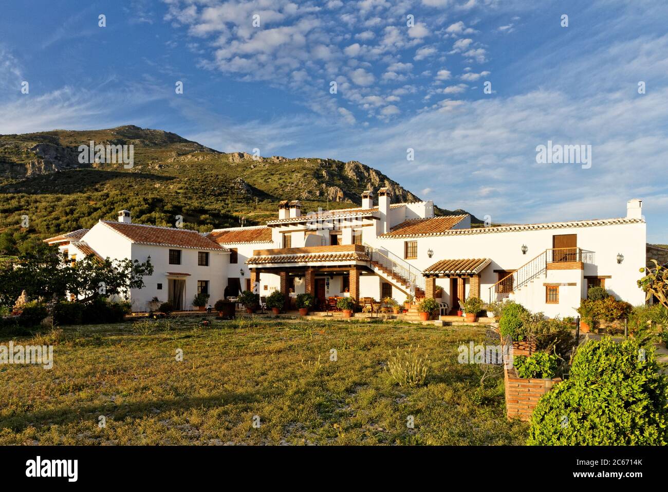 Casa di campagna imbiancata di bianco con cortile nella campagna spagnola, Finca Cortijo Las Monjas, Malaga, Andalusia, Spagna.Blue cielo caldo sera al tramonto Foto Stock