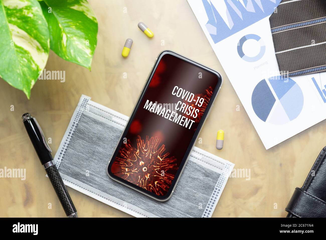 Coronavirus Covid-19 pandemia epidemia crisi Gestione concetto di base. Telefono cellulare mockup con business grafici, maschera, tablet medici su o Foto Stock