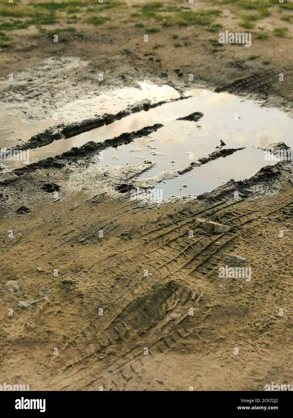 Pudddles in giorno piovoso. Campo fangoso, strada sterrata dopo la pioggia. Puddle e fango con la consistenza della pista degli pneumatici. Impassibilità delle strade. Concetto di impotenza Foto Stock