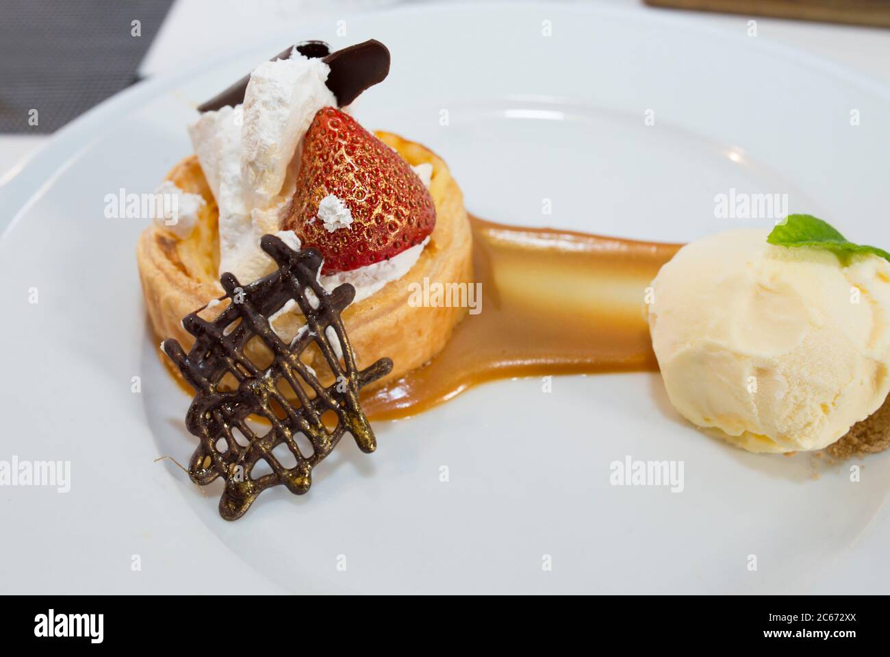 Dessert di alta cucina rivestito di polvere d'oro commestibile. Sfoglia ripiena di creme brulee, lampone e mattonelle di cioccolato con vaniglia Madagascar Foto Stock