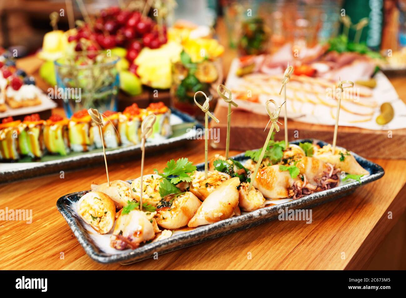 Calamari ripieni cucinati in stile asiatico e un altro cibo, tavolo da catering, tonato Foto Stock