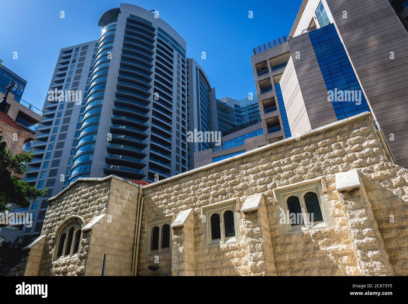 Vista laterale della chiesa della Congregazione Internazionale di tutti i Santi e dell'edificio residenziale della Torre della Baia di Beirut, Libano Foto Stock