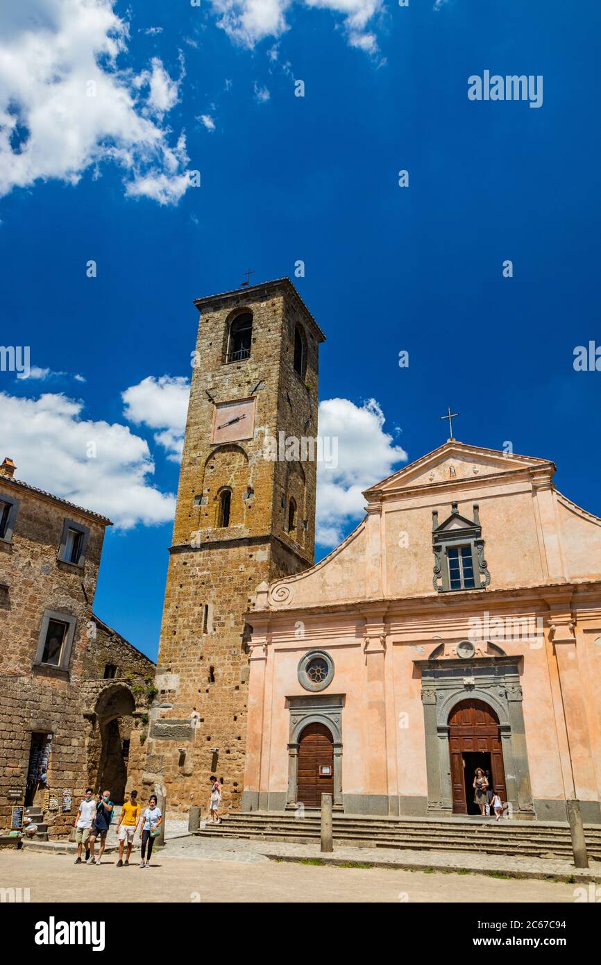 28 giugno 2020 - Civita di Bagnoregio, Viterbo, Tuscia, Lazio, Italia - la Chiesa di San Donato con il campanile e l'orologio. Tre porte in legno. Foto Stock
