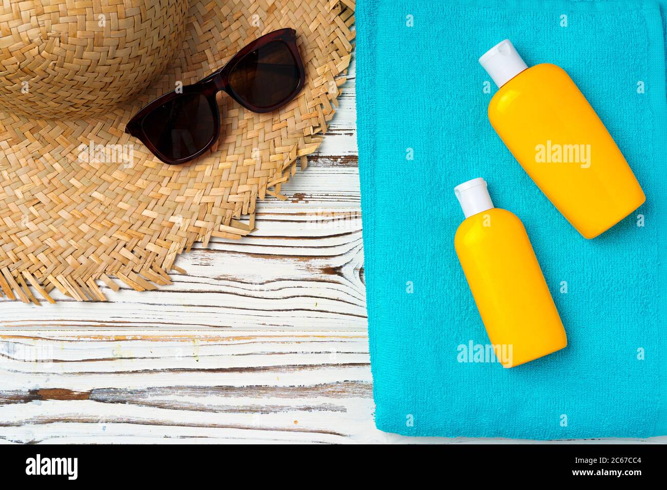 Cappello da spiaggia e bottiglia di crema solare. Concetto di vacanza Foto Stock