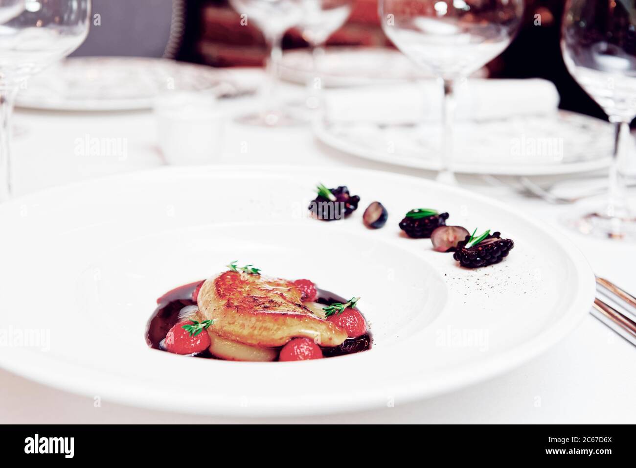 Foie gras con salsa al porto sul tavolo in un costoso ristorante francese, tonato Foto Stock