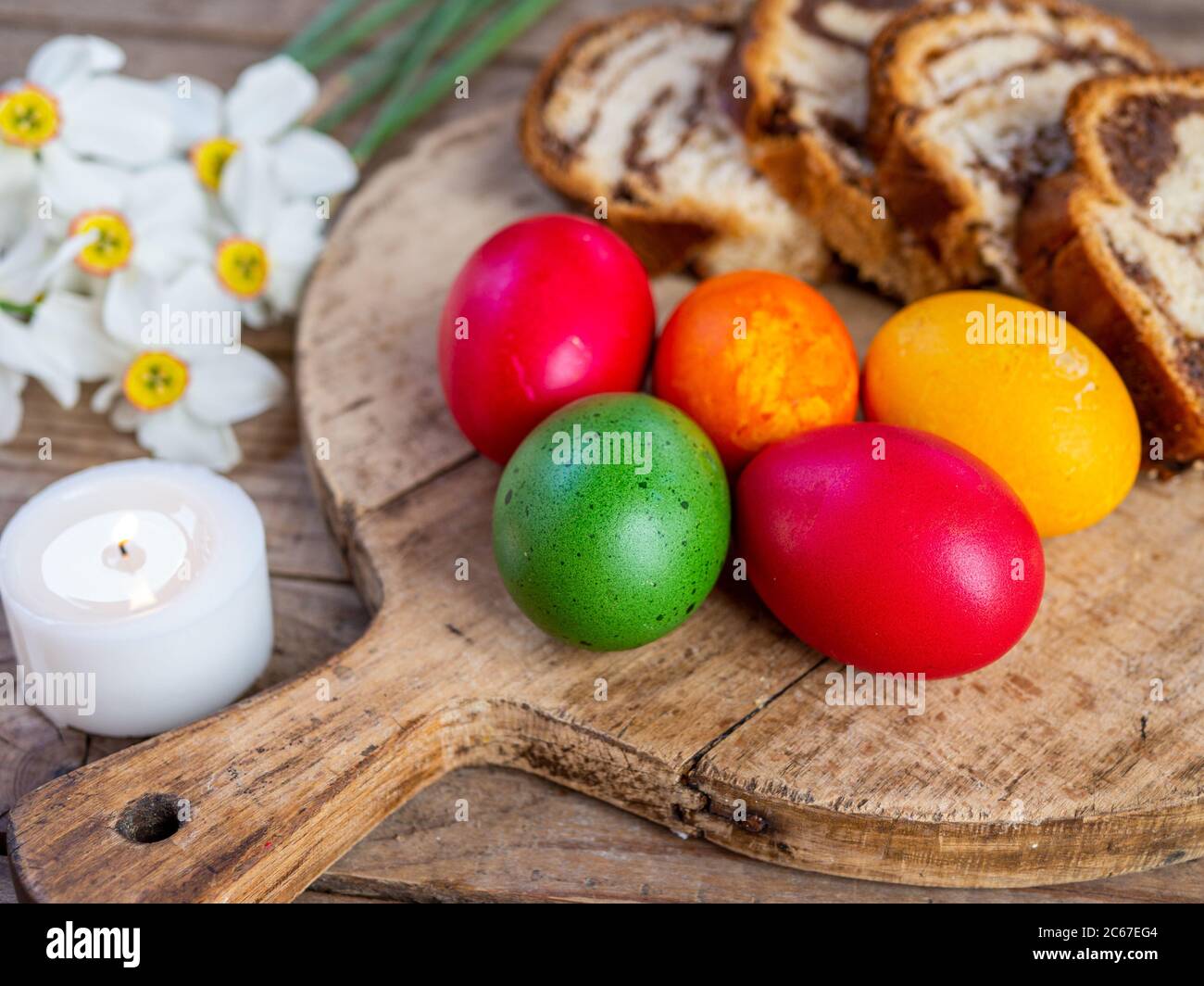 tradizionale rumeno piatto pasquale cozonac o animelle su tavola di legno e colorato uova di pasqua e fiori Foto Stock