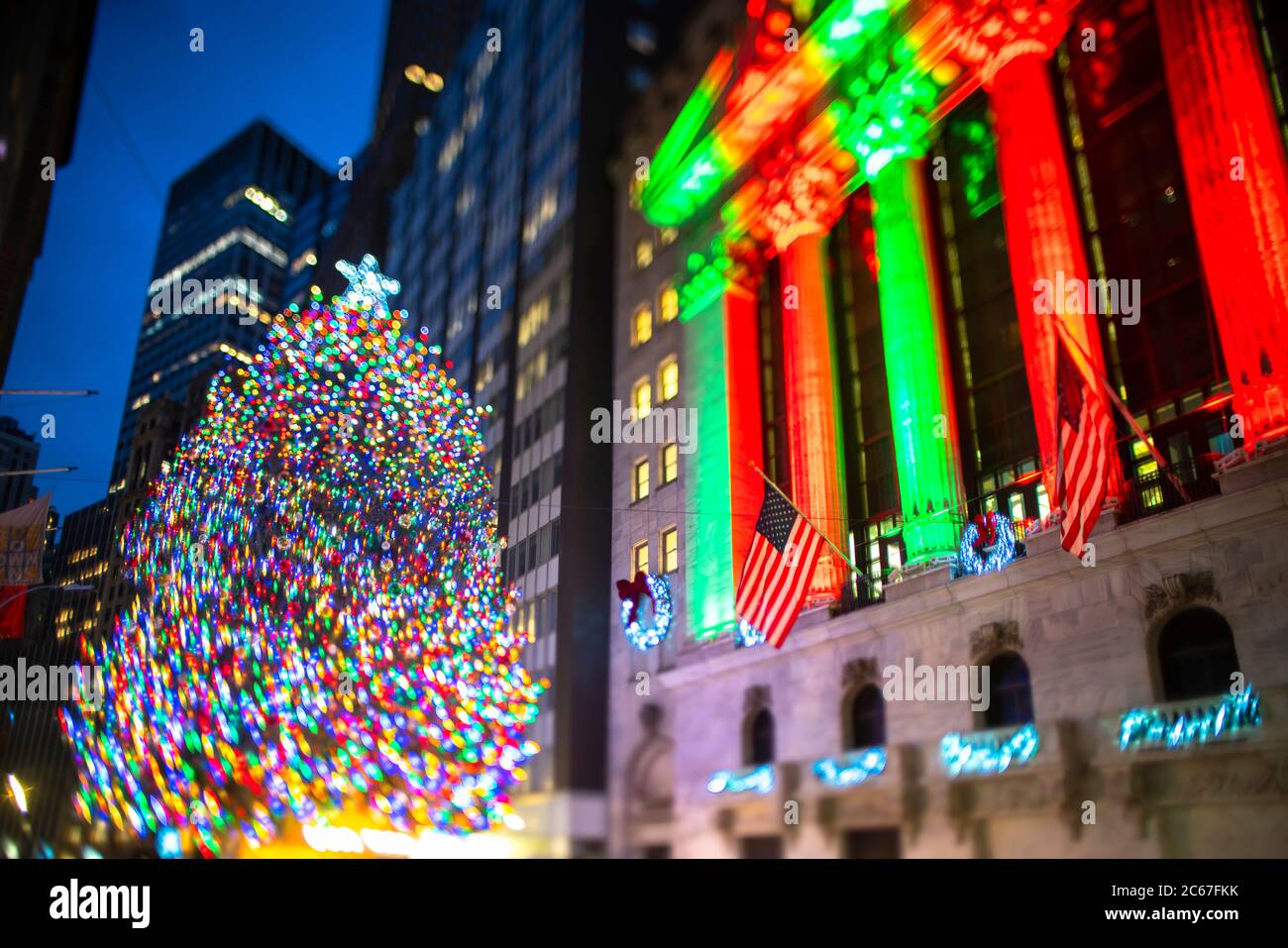 Il grande albero di Natale si illumina di fronte al New York Stock Exchange Building Foto Stock