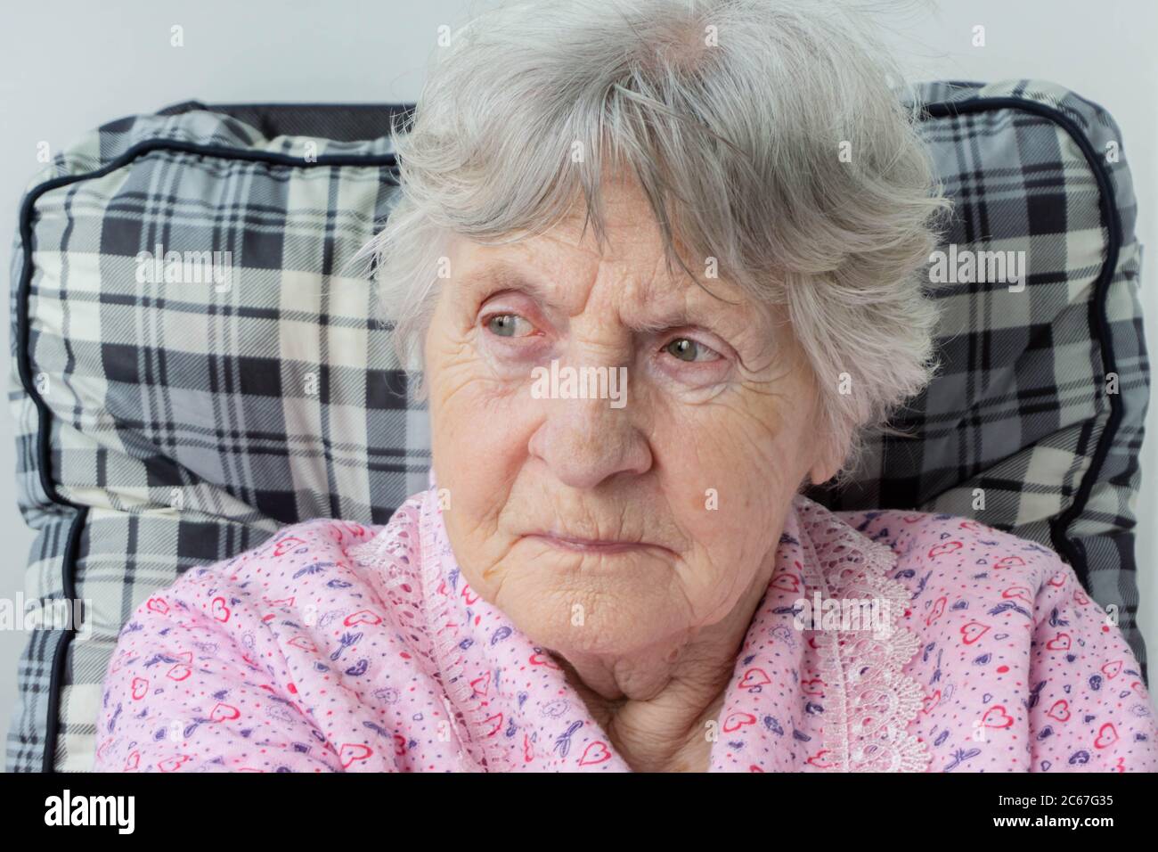 Ritratto di vecchia donna anziana con rughe sul viso e capelli grigi. Signora sambuco con viso rugoso. Primo piano di una madre seduta in sedia. Nonna por Foto Stock