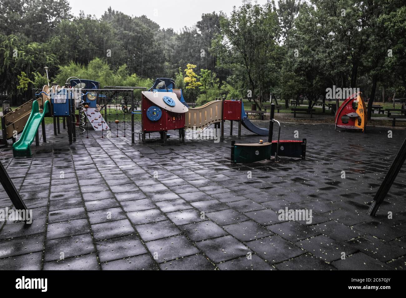 Parco giochi vuoto per bambini durante una giornata estiva piovosa. Foto Stock