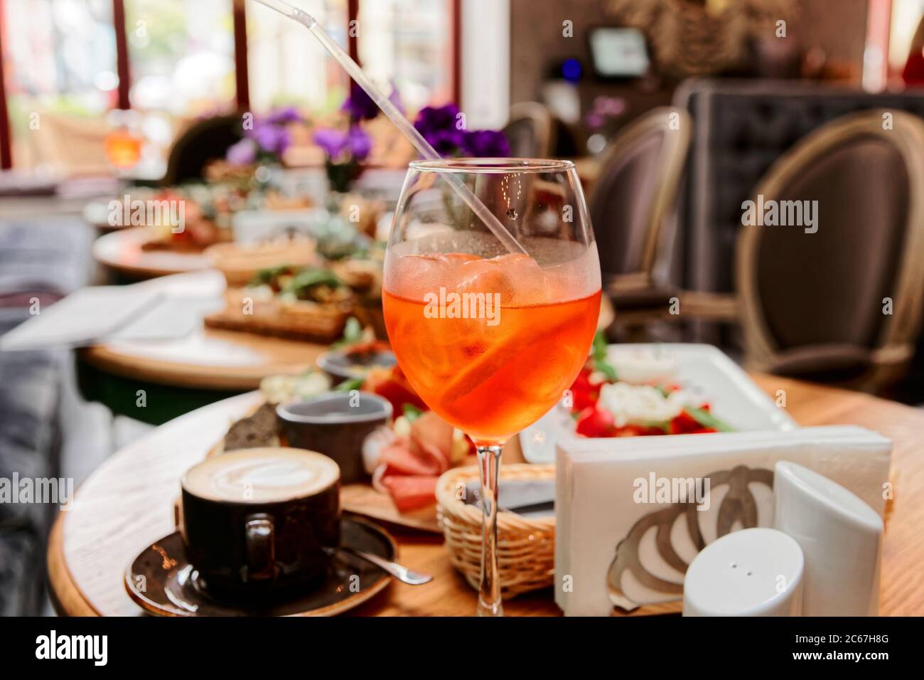 Cocktail Spritz fizz e vari piatti italiani sul tavolo del ristorante, tonati Foto Stock