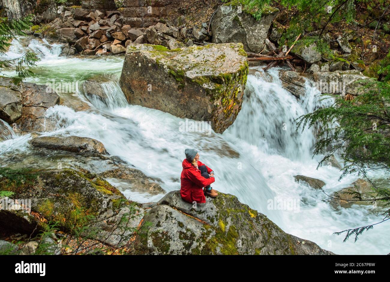 Vista della donna vicino al fiume sulla Deception Falls National Recreation Area, Washington, USA Foto Stock