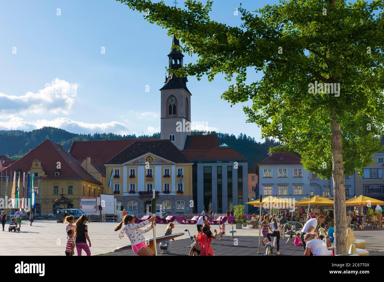 Bruck an der Mur: Piazza principale Koloman-Wallisch-Platz, chiesa parrocchiale, parco giochi per bambini a Murau-Murtal, Steiermark, Stiria, Austria Foto Stock