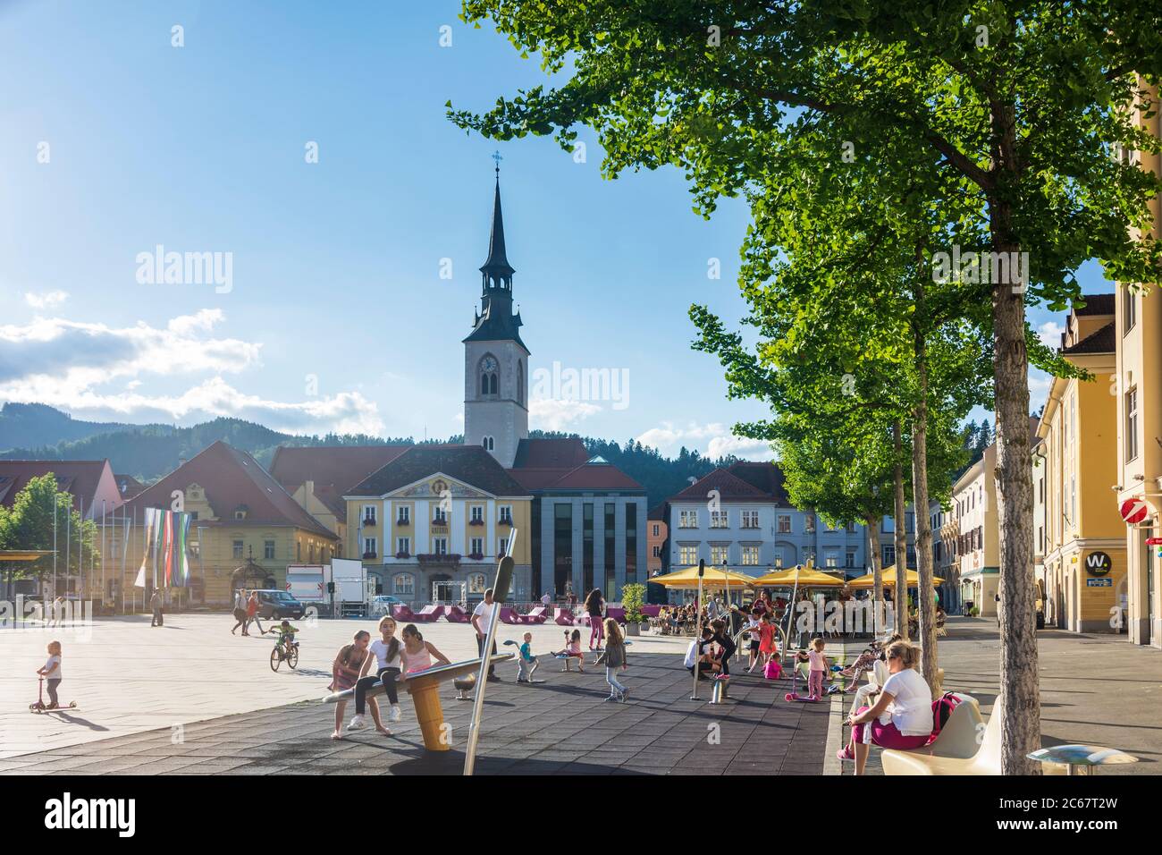 Bruck an der Mur: Piazza principale Koloman-Wallisch-Platz, chiesa parrocchiale, parco giochi per bambini a Murau-Murtal, Steiermark, Stiria, Austria Foto Stock